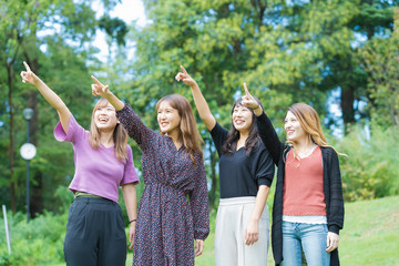 空を指差す4人の女性