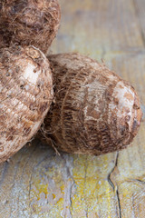 Closeup of malangas on weathered wooden background in vertical with copy space
