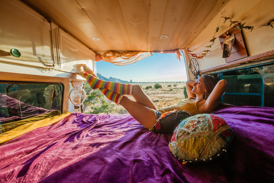 Woman relaxing on bed in camper van