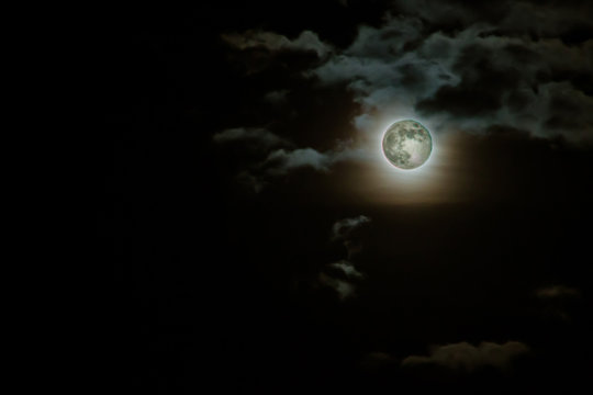 Fondo para Halloween. Cielo nocturno con la luna llena entre nubes.