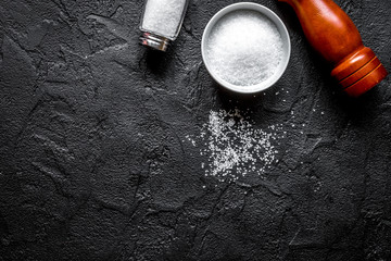 salt in glass bottle scattered on dark table background top view space for text