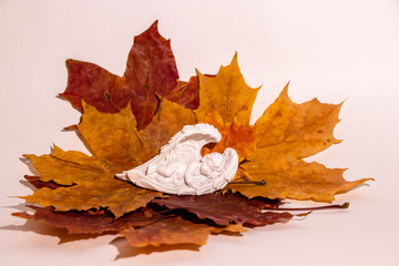 The figure of a white angel sleeping in the autumn leaves