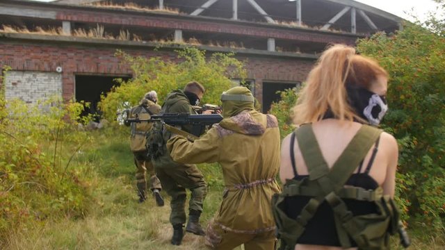 Kaliningrad, Russia - August, 2019: Laser tag game. Soldiers are aiming. Men plays airsoft in the forest. Martial law. Medium shot.