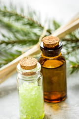 spa with organic spruce oil and sea salt in glass bottles on white table background