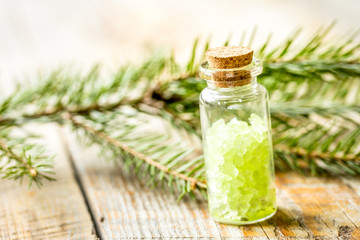 Spruce spa with organic salt in bottles on wooden table background