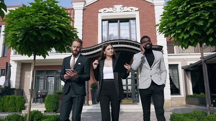 Young mixed races team of three business people talking each other about important meeting their partners of job outdoors near leaving the office