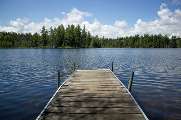 Small Wooden Dock On Beautiful Blue Pond In The Forest