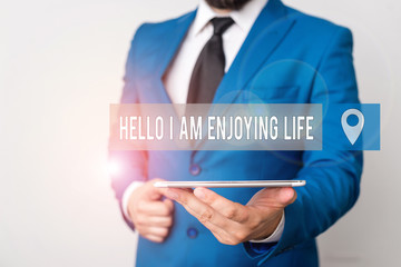 Writing note showing Hello I Am Enjoying Life. Business concept for Happy relaxed lifestyle Enjoy simple things Businessman in blue suite with a tie holds lap top in hands