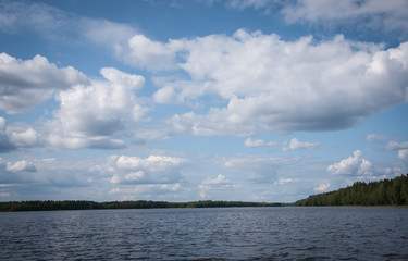 Naklejka na ściany i meble Summer view of the lake Hallanlahti with clouds on blue sky .