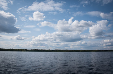 Fototapeta na wymiar Summer view of the lake Hallanlahti with clouds on blue sky .