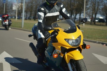 yellow sports bike on the road with a motorcyclist on it