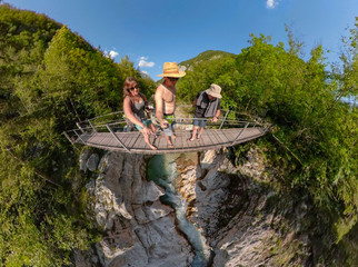 SELFIE: Three young travelers and puppy cross the suspension bridge over Soca