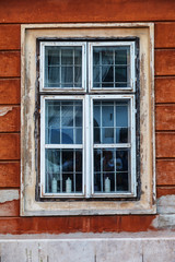 Old window with frames on the wooden wall of the rural house