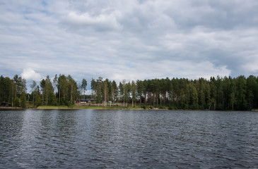 Fototapeta premium Summer view of the lake Hallanlahti with reflection of clouds on the surface of the water . Finland .