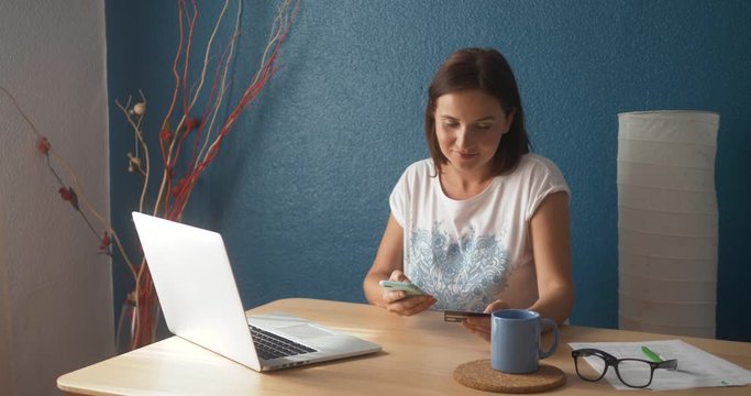 Portrait of a woman buying online or booking hotel with a laptop and credit card in vacations. E commerce concept