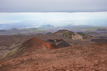 Volcanic landscape with frozen lava fields in cloudy weather on mountain peaks.