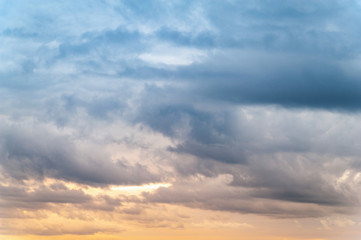 Fototapeta premium Ciemne chmury. Niebo z ciężkimi ciemnymi chmurami wieczorem o pomarańczowo-różowym zachodzie słońca.