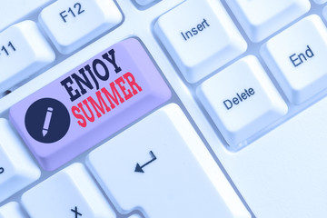 Text sign showing Enjoy Summer. Business photo text taking a break from school and spending holidays in the beach White pc keyboard with empty note paper above white background key copy space