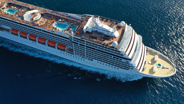 Aerial top view photo of huge cruise liner with pools and outdoor facilities cruising the Atlantic blue ocean