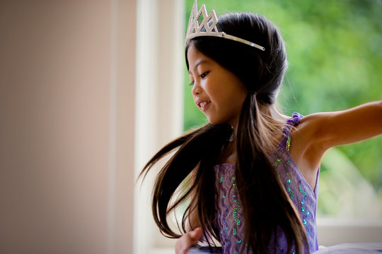 Happy young girl wearing pigtails and a tiara.