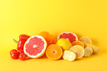 Different vegetables and fruits on yellow background, copy space