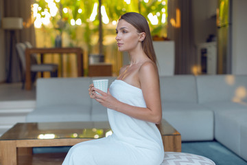 Young sexy girl in the morning in a towel with a cup of tea