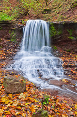 Fototapeta na wymiar Beautiful waterfall on a mountain stream in the woods