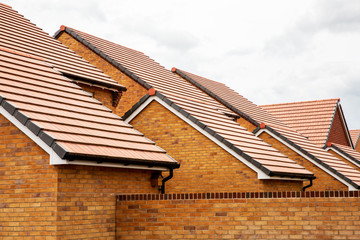 Exterior view of yellow brick row house with yellow roof tiles.,Harwell