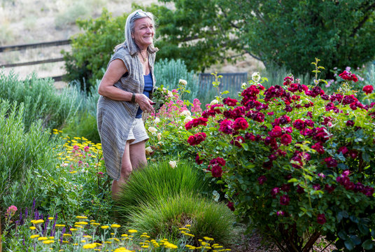 Smiling senior woman standing in her garden