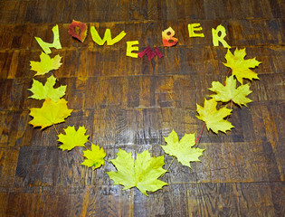 Heart and word november from autumn leaves on parquet background