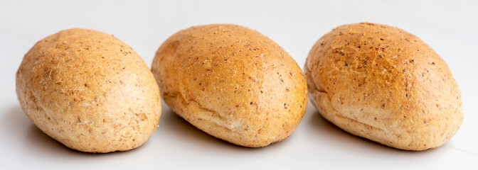 Tasty dark graham buns on white background, copy space. Bakery products, whole wheat bunsBakery products, whole wheat buns