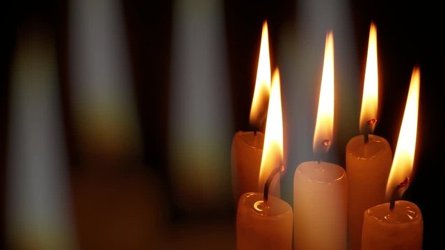 Burning memorial candles on black background
