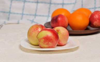 Fresh juicy oranges on the  grey background.Tray of Fresh red nectarines. Wooden background. Top view