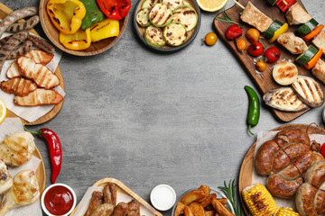 Fototapeta na wymiar Frame of barbecued meat and vegetables on grey table, flat lay. Space for text