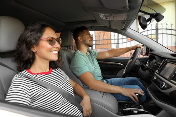 Happy young couple traveling by family car on summer day