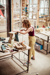 High angle view of female carpenter working over wooden table in workshop