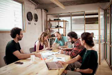 Carpenters working over laptops at desk in office
