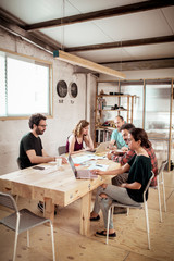Colleagues working at desk in office at workshop