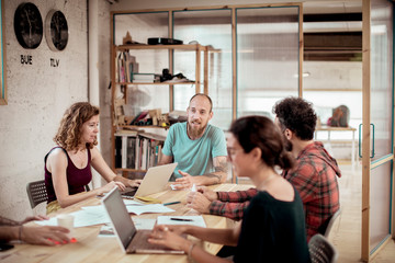 Colleagues discussing at desk in office