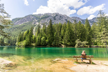 Fototapeta na wymiar Woman on Bench at the Green Lake in Styria, Austria