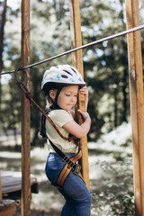 little girl runs obstacles in a rope park
