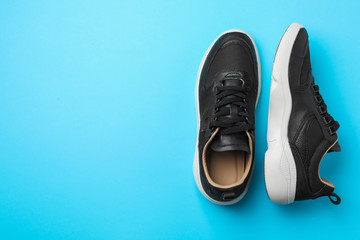 Pair of stylish shoes on blue background, top view. Space for text