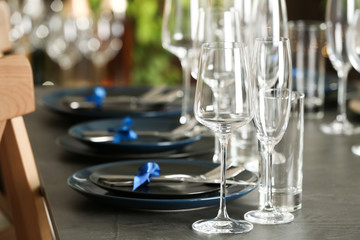 Table setting with empty glasses, plates and cutlery indoors