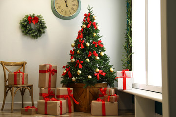 Decorated Christmas tree with gifts. Festive interior