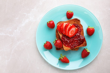 Toasts with jam and strawberries on light grey marble table, top view. Healthy breakfast