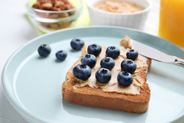 Toast with peanut butter and blueberries on white table, closeup. Healthy breakfast