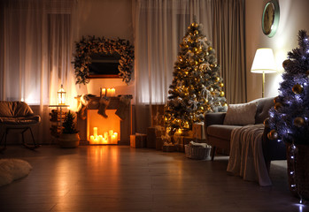 Stylish interior with beautiful Christmas tree and decorative fireplace at night