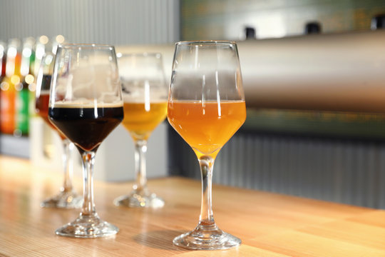 Different sorts of beer on wooden bar counter