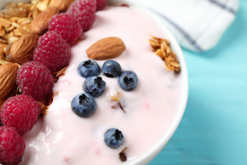 Tasty homemade granola served on blue wooden table, closeup. Healthy breakfast