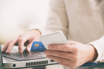 Womans hand holding credit card and smartphone